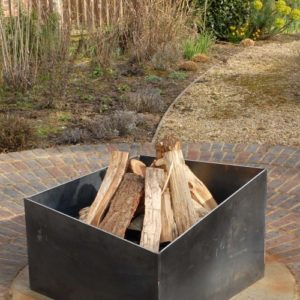 Basalt fire pit from the side. A contemporary modern metal geometric or square firepit.