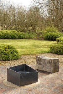 Basalt fire pit from the side. A contemporary modern metal geometric or square firepit.