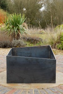 Basalt fire pit from the side. A contemporary modern metal geometric or square firepit.